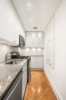 a large kitchen with stainless steel appliances granite countertop a stove a sink and a granite counter tops