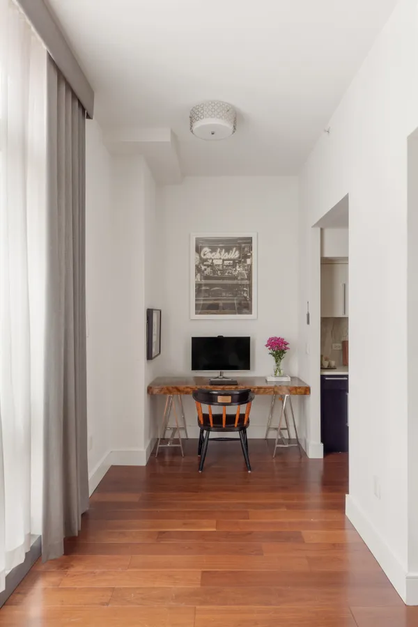 a view of a workspace with furniture and wooden floor