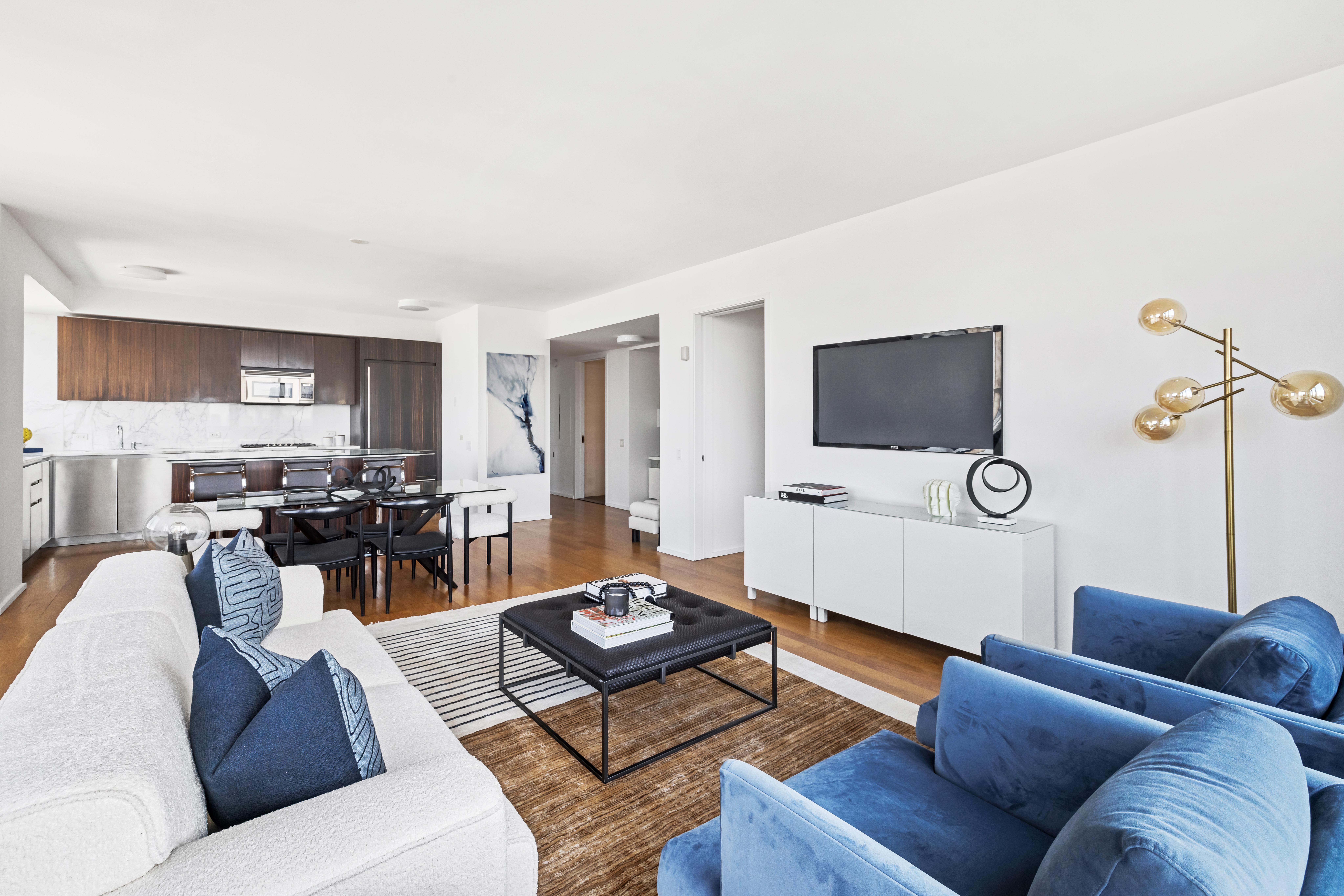 515 East 72nd Street, Unit 40E Manhattan, NY 10021 - Photo 16 of 34 a living room with furniture a flat screen tv and kitchen view