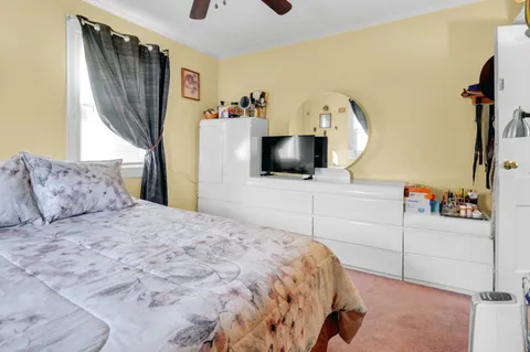 a bedroom with a large bed and a flat tv screen on dresser
