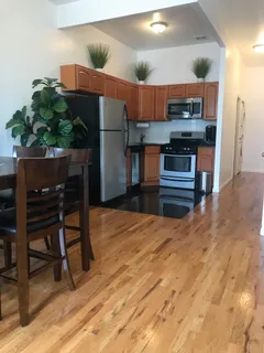 a kitchen with stainless steel appliances kitchen island granite countertop a refrigerator and a stove top oven