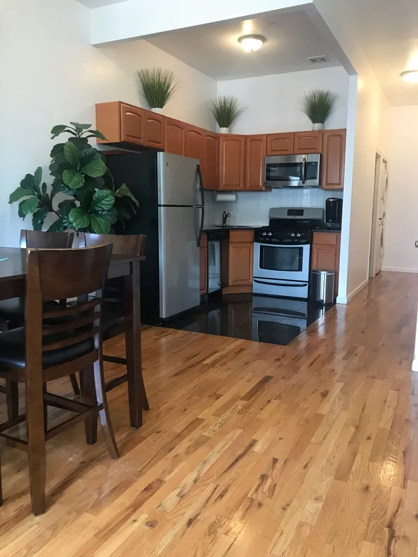 a kitchen with stainless steel appliances kitchen island granite countertop a refrigerator and a stove top oven