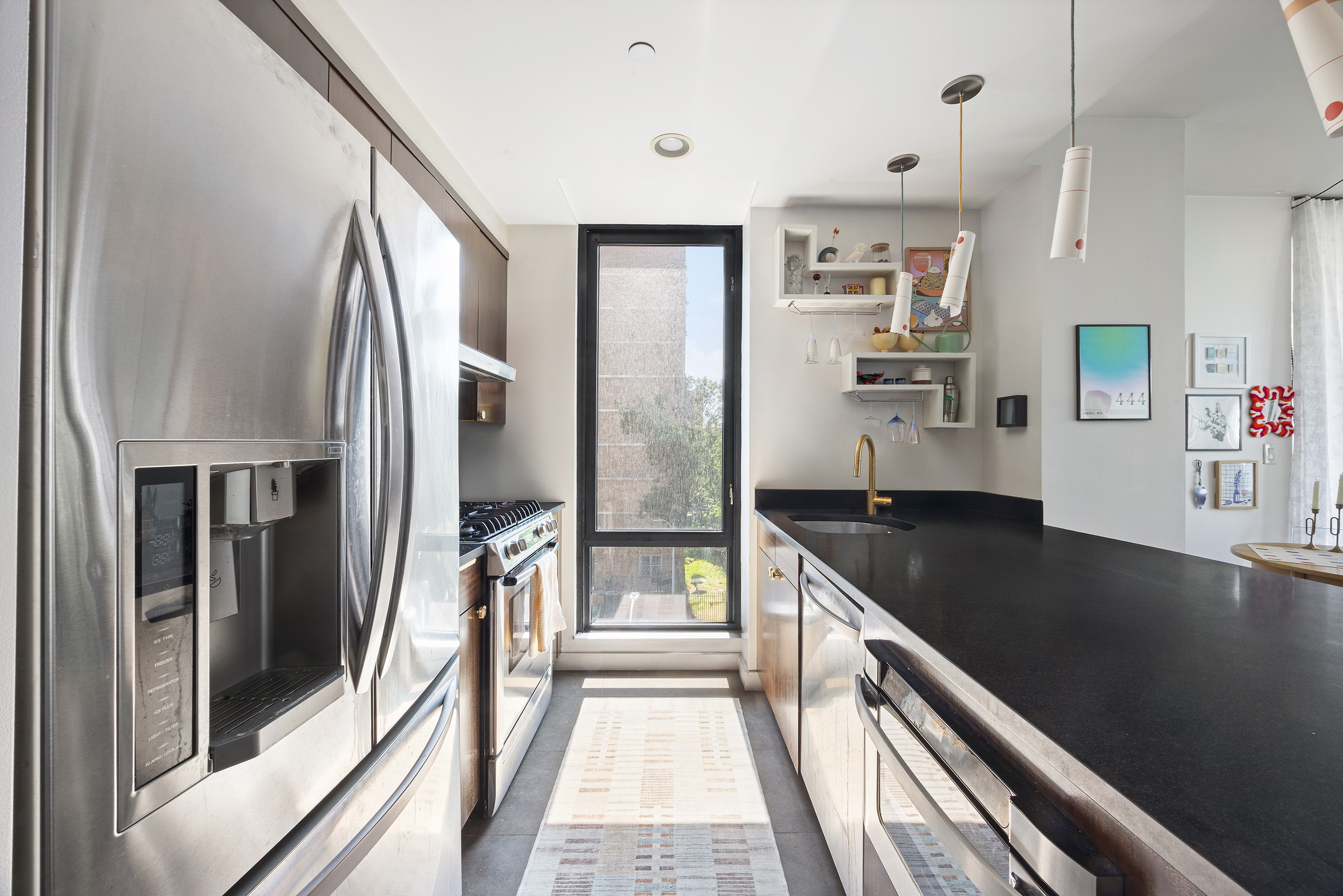215 Avenue B, Unit 4A Manhattan, NY 10009 - Photo 5 of 13 a kitchen with stainless steel appliances granite countertop a refrigerator and a sink