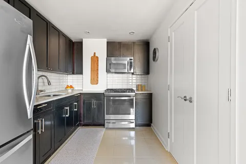 a kitchen with stainless steel appliances granite countertop a refrigerator and a stove top oven