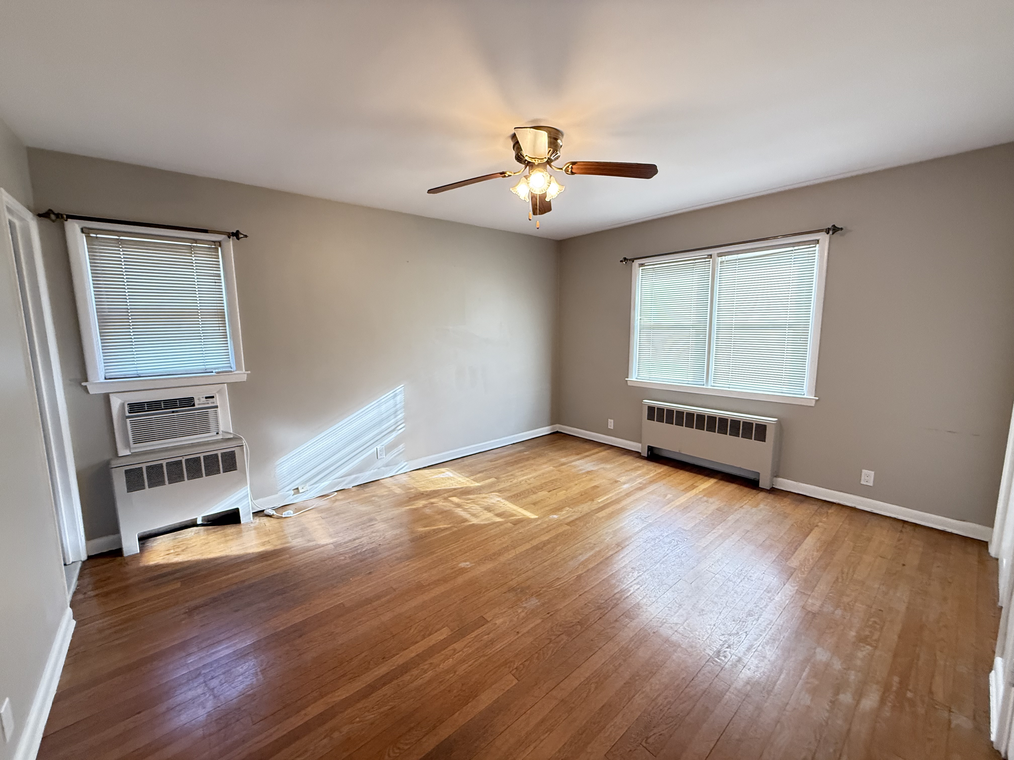 3236 Country Club Road Bronx, NY 10465 - Photo 11 of 22 wooden floor in an empty room with a window