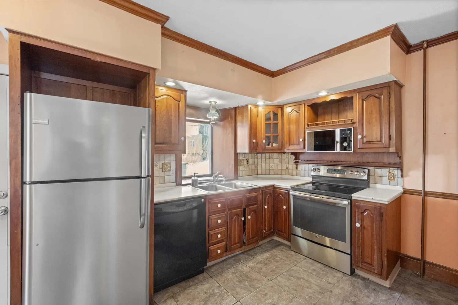 a kitchen with stainless steel appliances granite countertop a refrigerator a sink and a stove