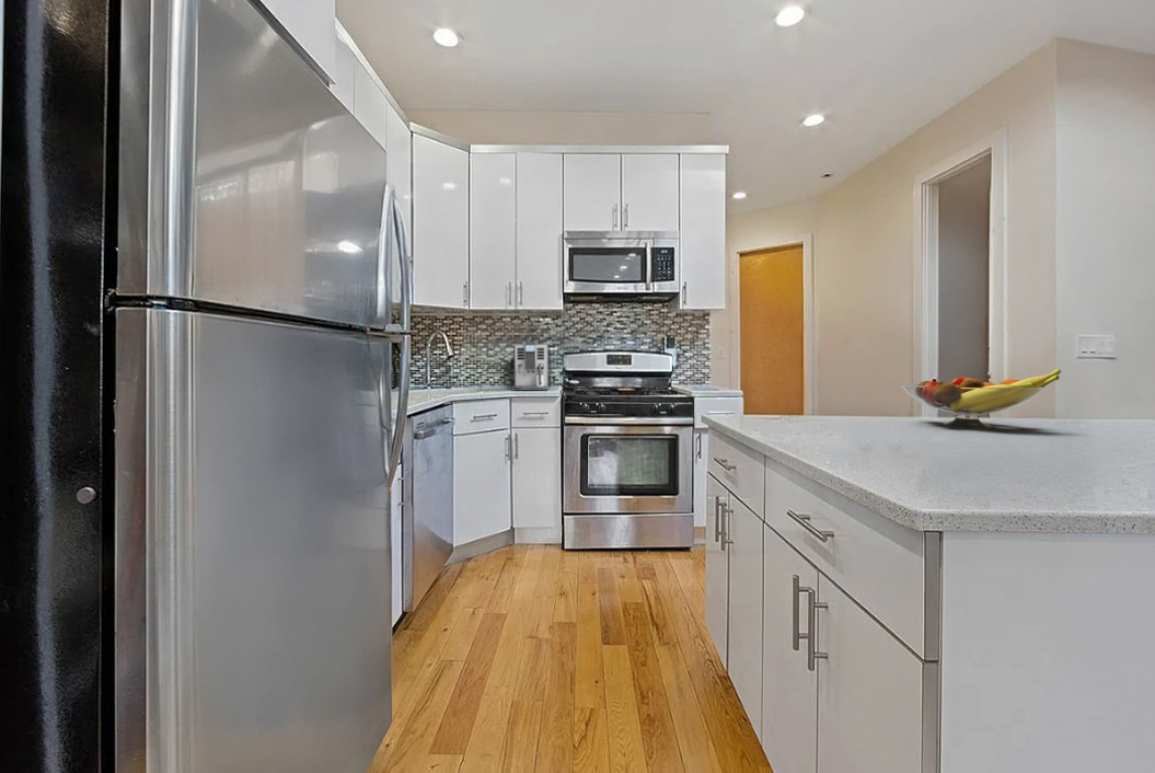 426 Rogers Avenue Brooklyn, NY 11225 - Photo 6 of 9 a kitchen with stainless steel appliances a refrigerator sink and microwave
