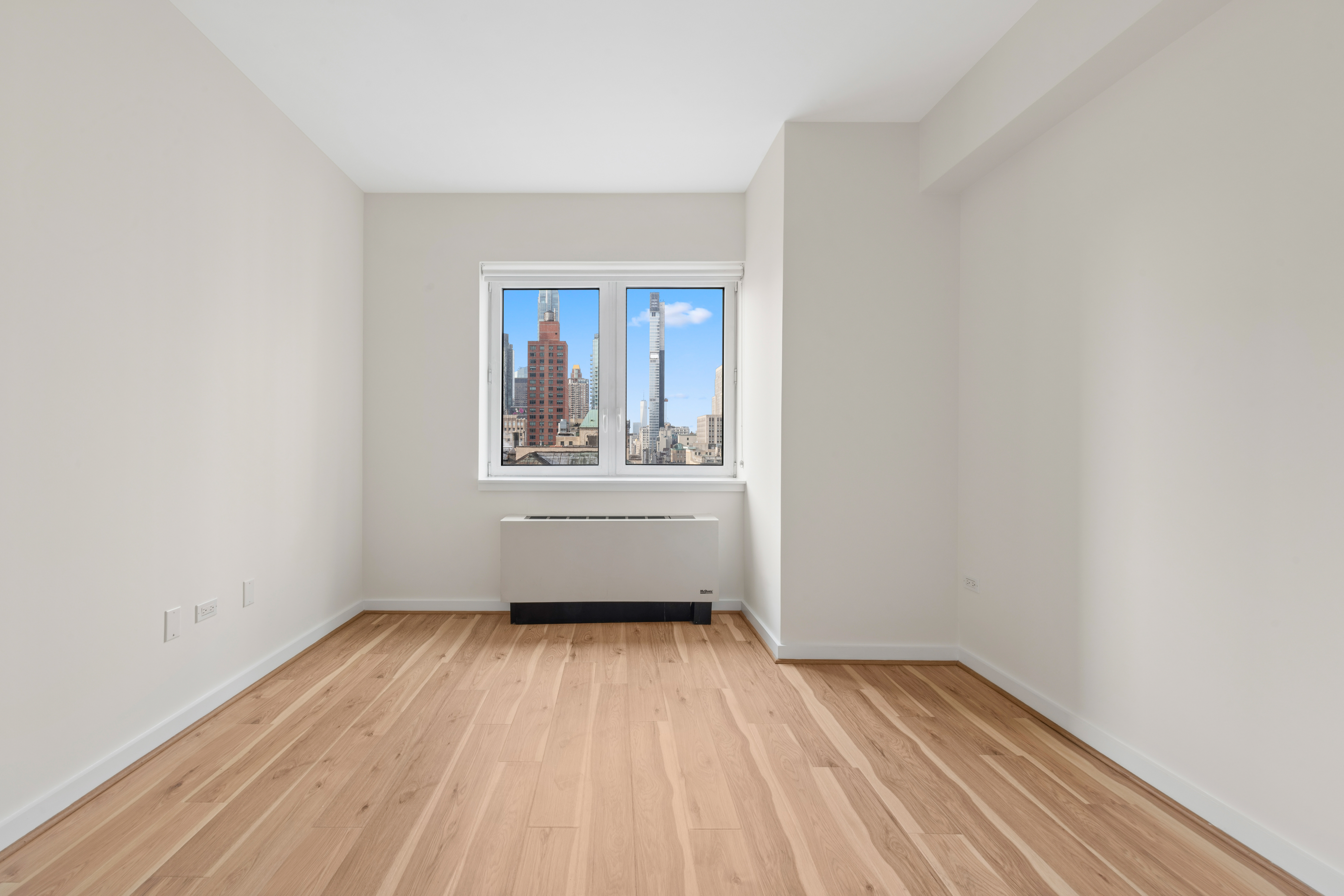 425 5th Avenue, Unit 23D Manhattan, NY 10016 - Photo 9 of 20 a view of an empty room with wooden floor and a window