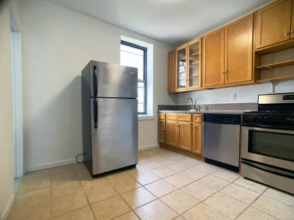 a kitchen with a refrigerator stove and wooden cabinets