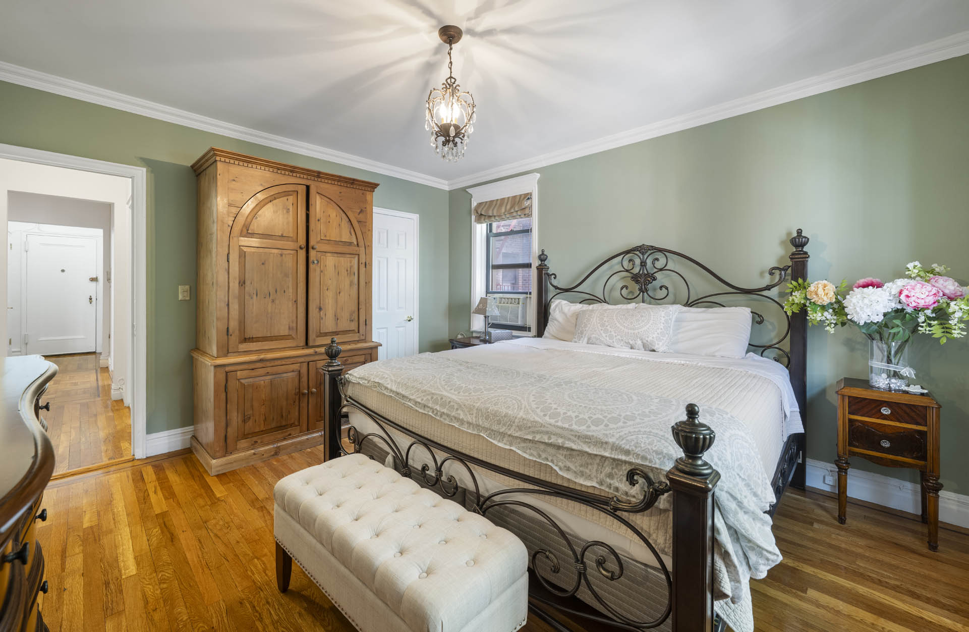 3215 Netherland Avenue, Unit 5C Bronx, NY 10463 - Photo 10 of 14 a bedroom with a bed and a chandelier