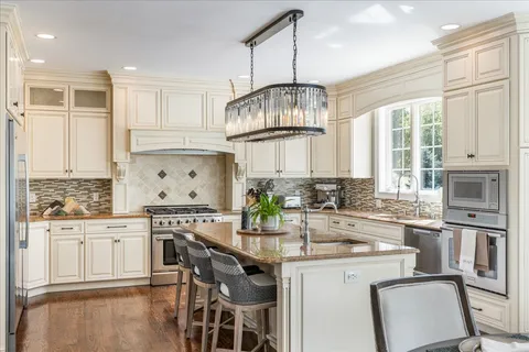 a kitchen with stainless steel appliances granite countertop a sink a stove and a microwave