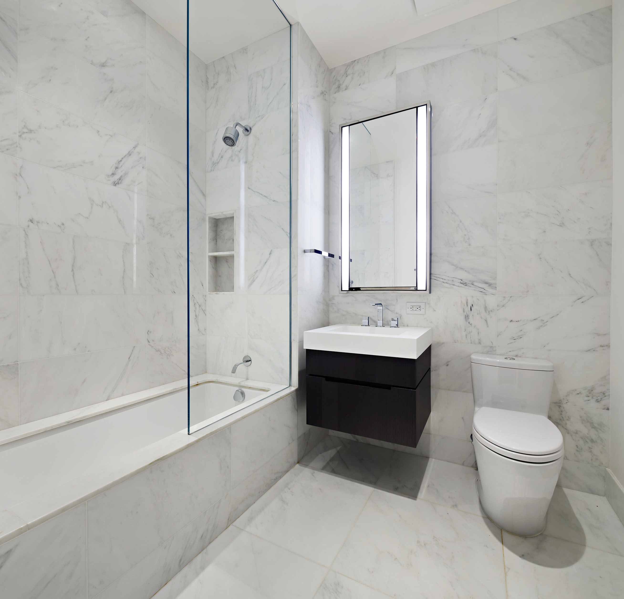 108 Leonard Street, Unit 9B Manhattan, NY 10013 - Photo 12 of 13 a bathroom with a bathtub shower sink mirror and toilet