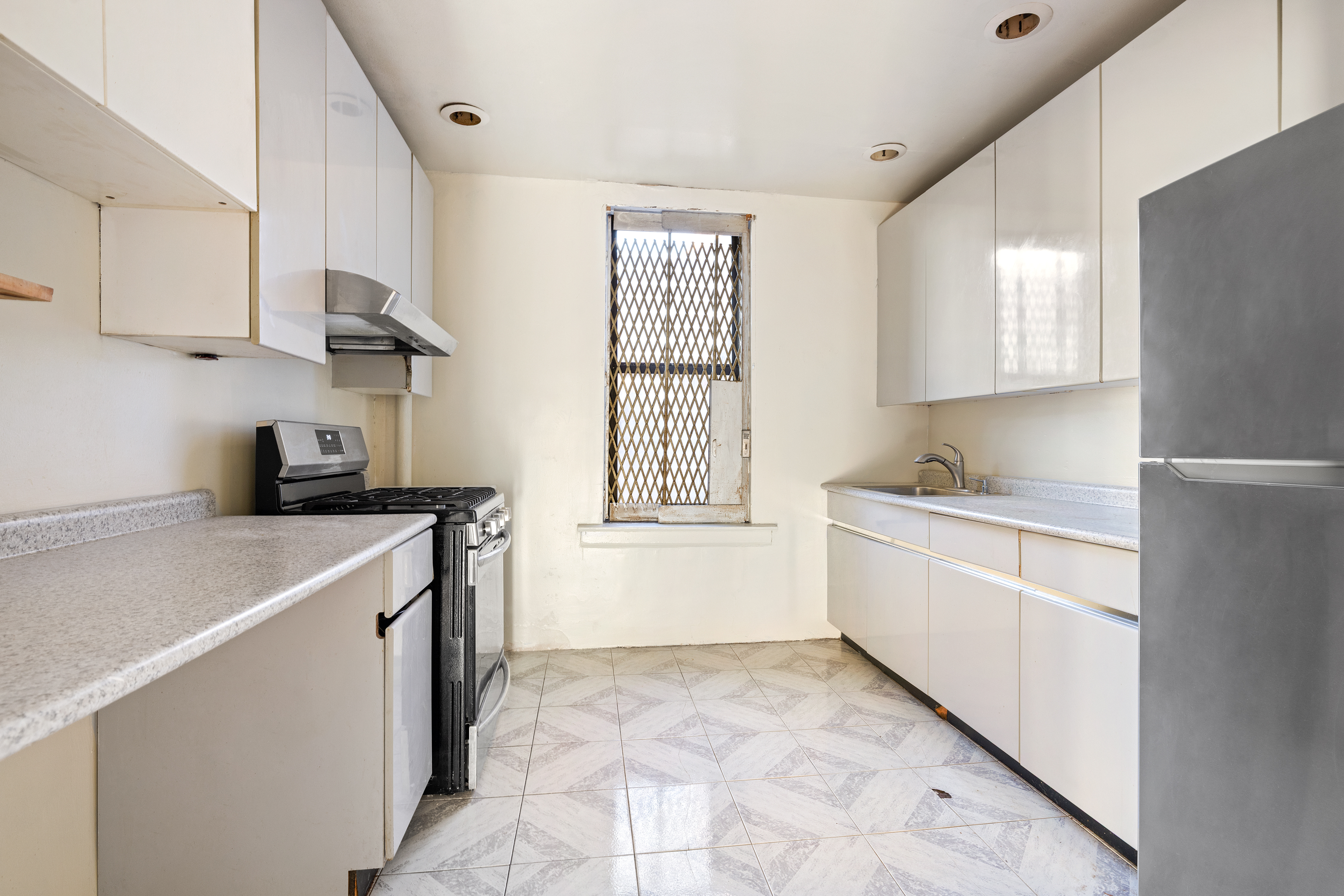 421 Crown Street, Unit 18R Brooklyn, NY 11225 - Photo 7 of 8 a kitchen with a cabinets and white appliances