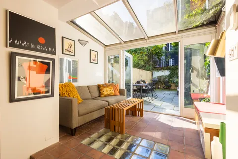 a living room with furniture a flat screen tv and a floor to ceiling window