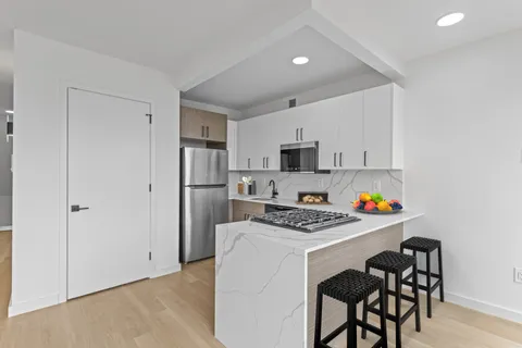 a kitchen with stainless steel appliances a white refrigerator stove a sink dishwasher and a refrigerator with wooden floor