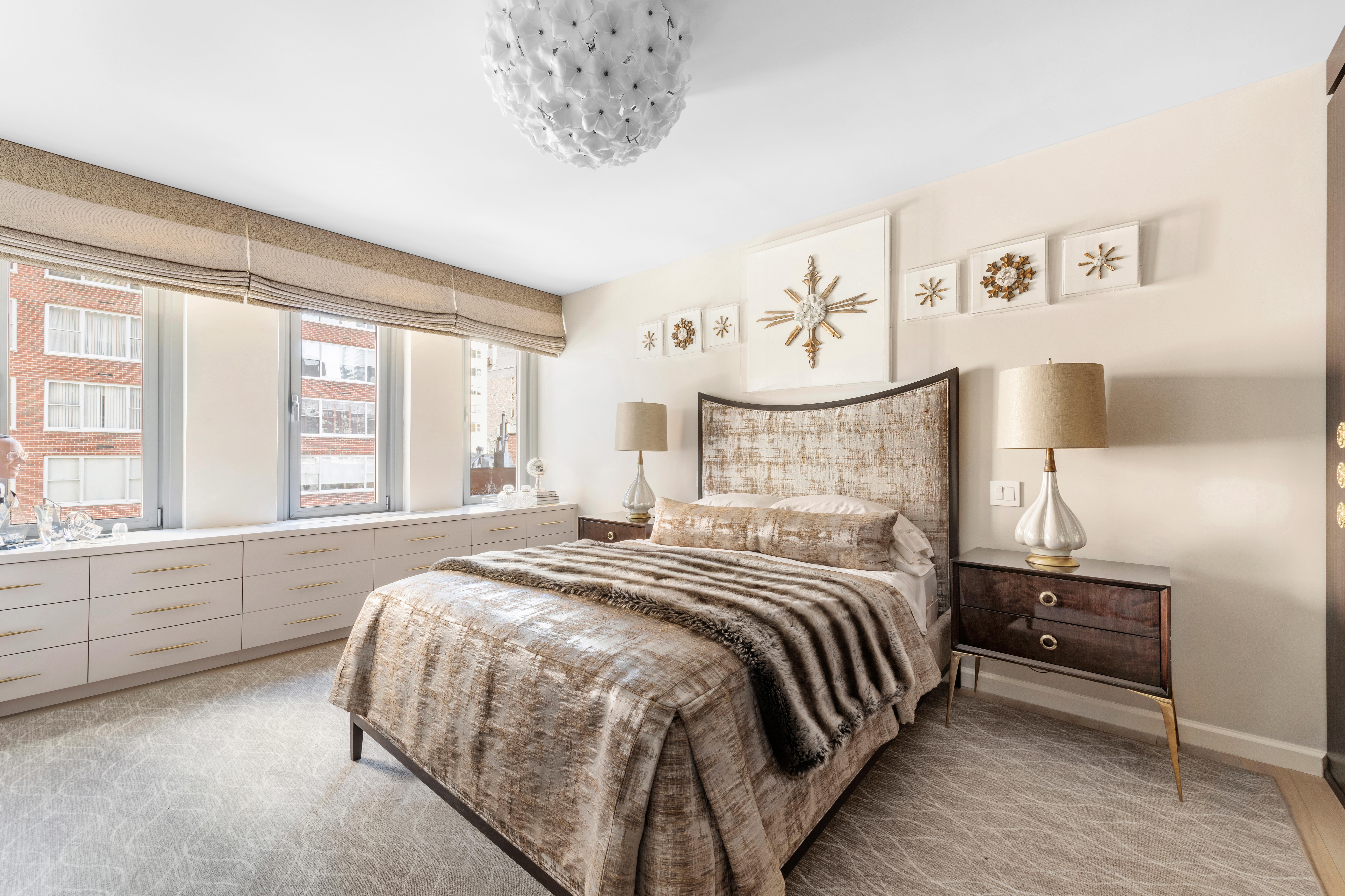 200 East 62nd Street, Unit 5A Manhattan, NY 10065 - Photo 10 of 25 a bedroom with a large bed and a chandelier