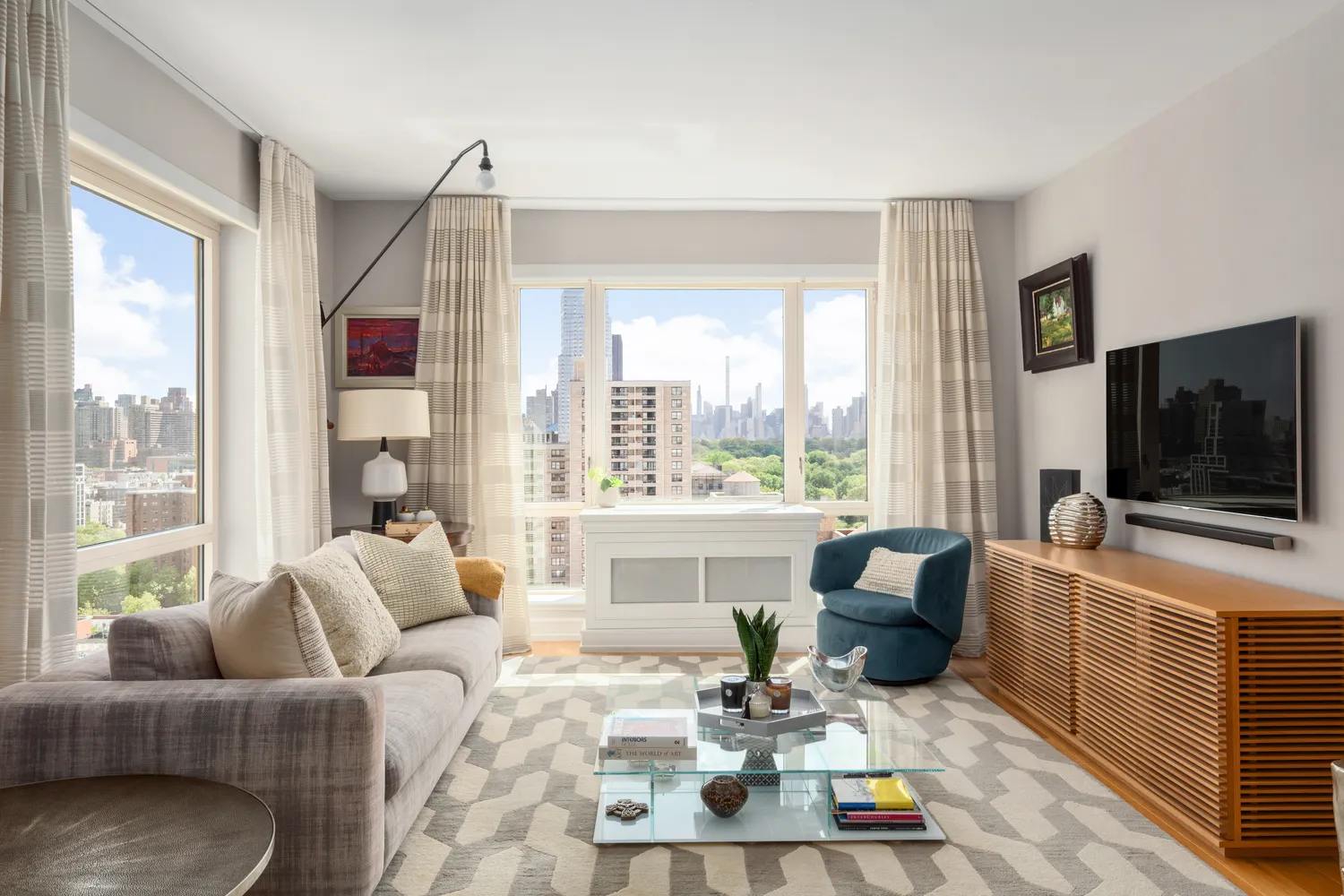 a living room with furniture a flat screen tv and a large window