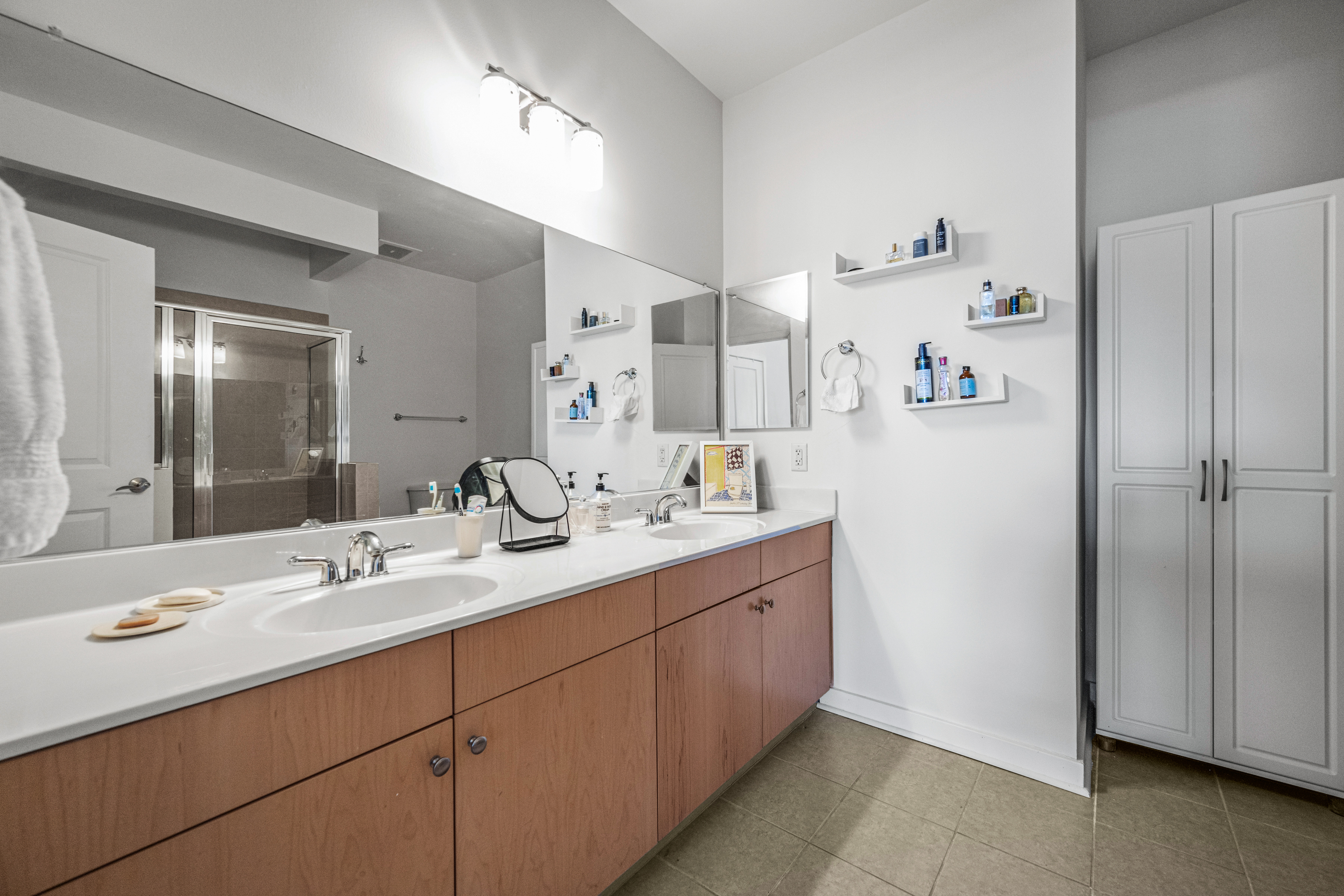 3201 St Paul Street, Unit 310 Baltimore, MD 21218 - Photo 4 of 20 a bathroom with a double vanity sink mirror and double