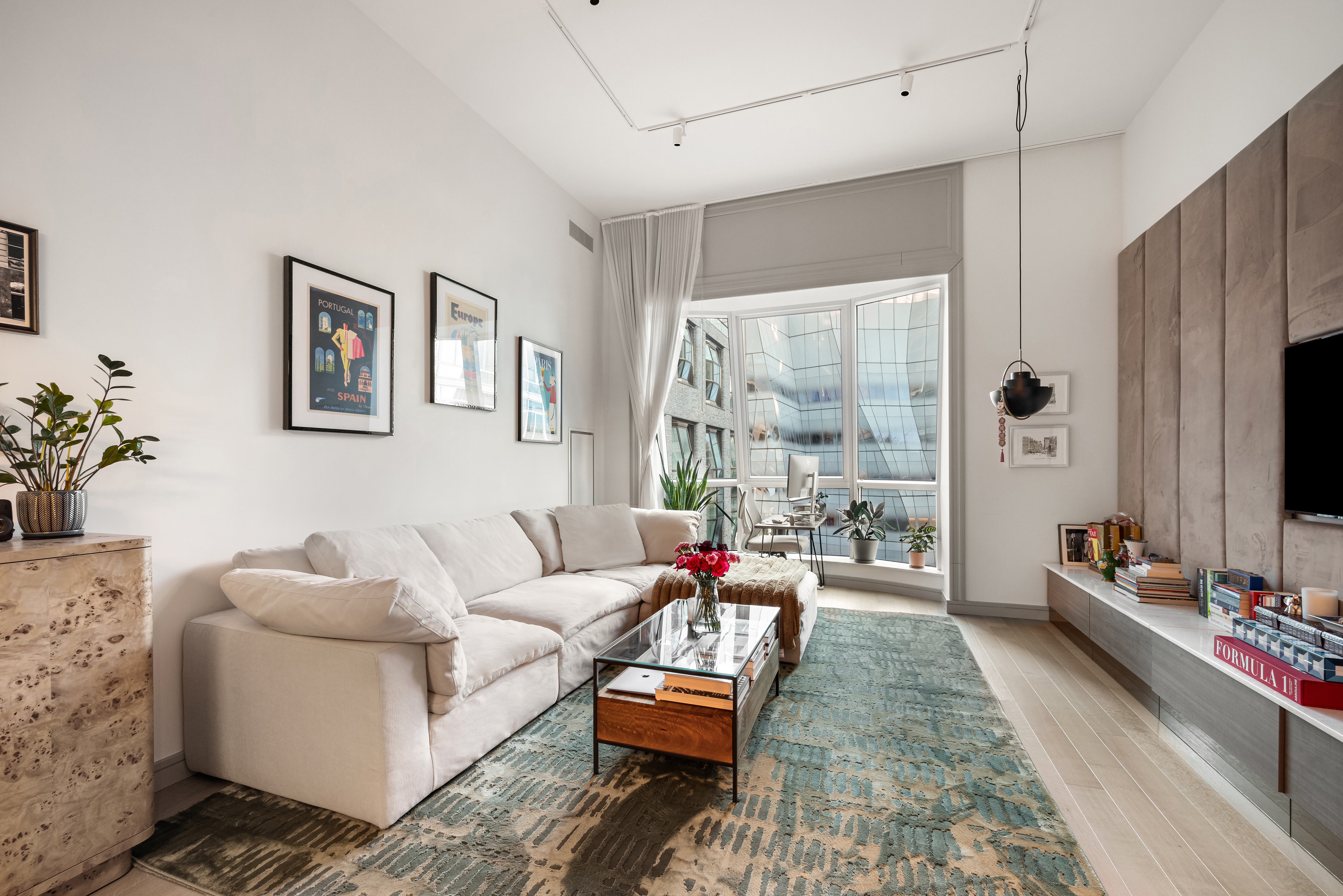 515 West 18th Street, Unit 901 Manhattan, NY 10011 - Photo 3 of 14 a living room with furniture and a flat screen tv