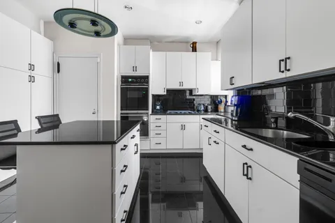 a kitchen with stainless steel appliances a sink a stove a microwave and cabinets