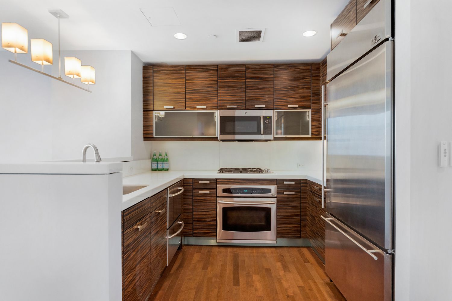 225 East 34th Street, Unit PHD Manhattan, NY 10016 - Photo 2 of 12 a kitchen with kitchen island stainless steel appliances a stove sink and microwave