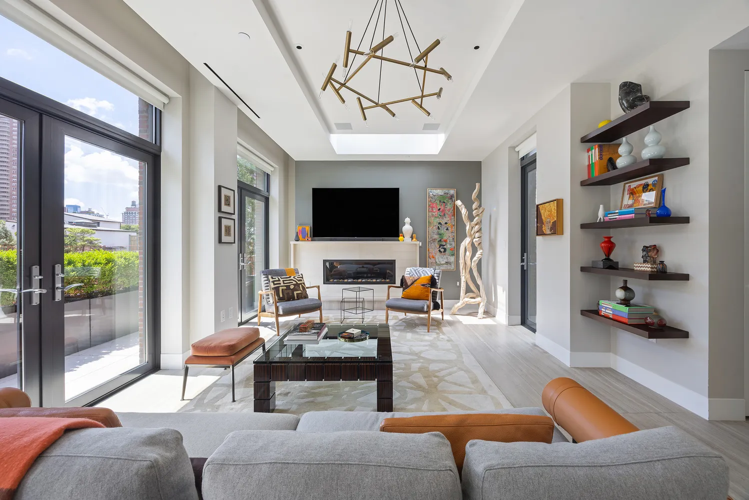 a living room with furniture a flat screen tv and a floor to ceiling window