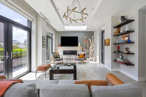 a living room with furniture a flat screen tv and a floor to ceiling window