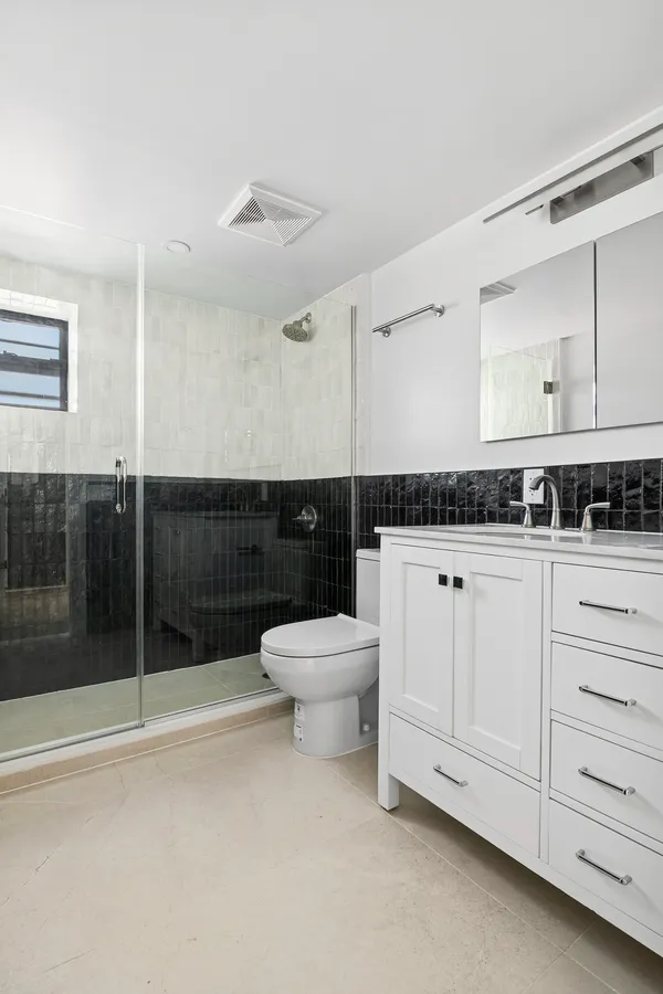 a bathroom with a sink a toilet and shower