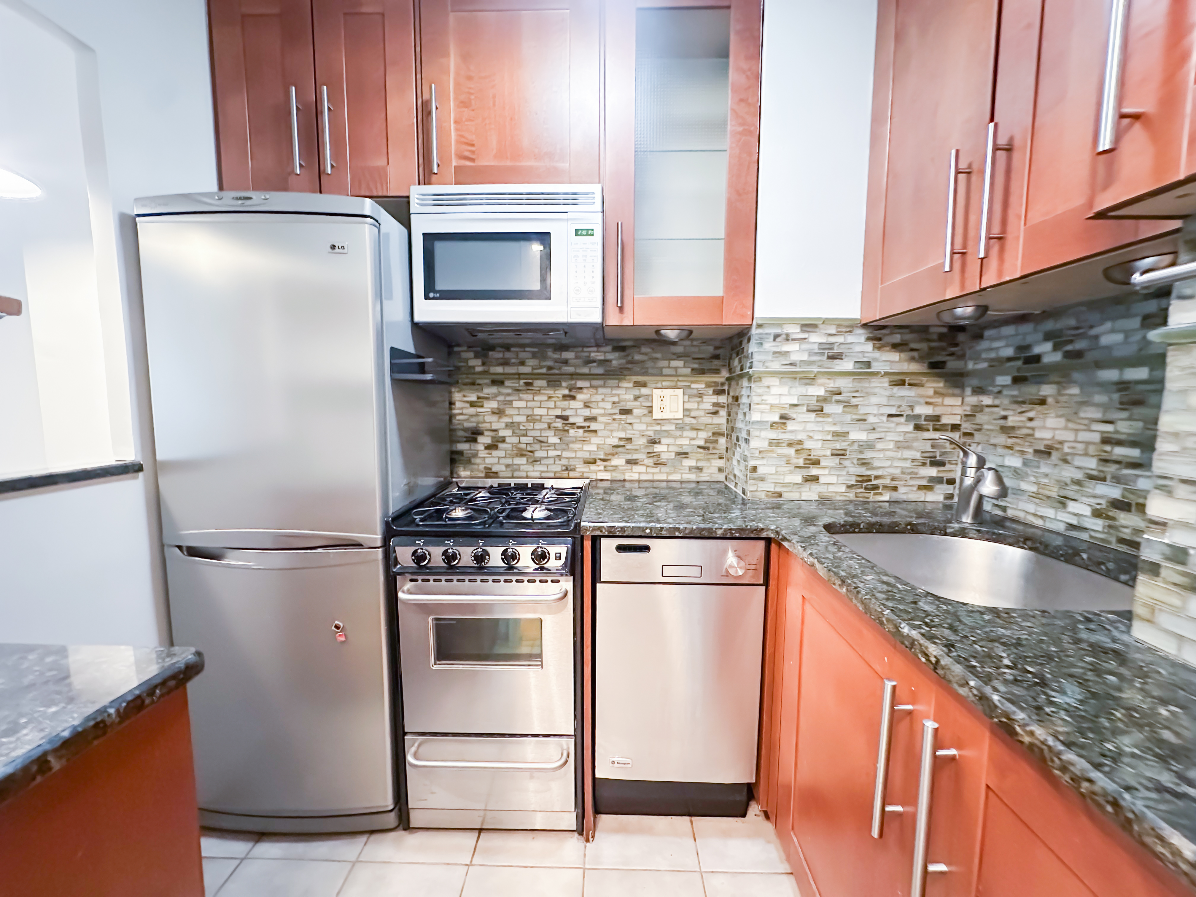 301 East 22nd Street, Unit 2H Manhattan, NY 10010 - Photo 1 of 16 a kitchen with granite countertop stainless steel appliances and white cabinets