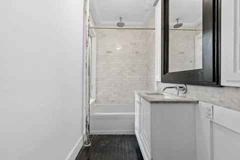 a bathroom with a granite countertop sink toilet and shower