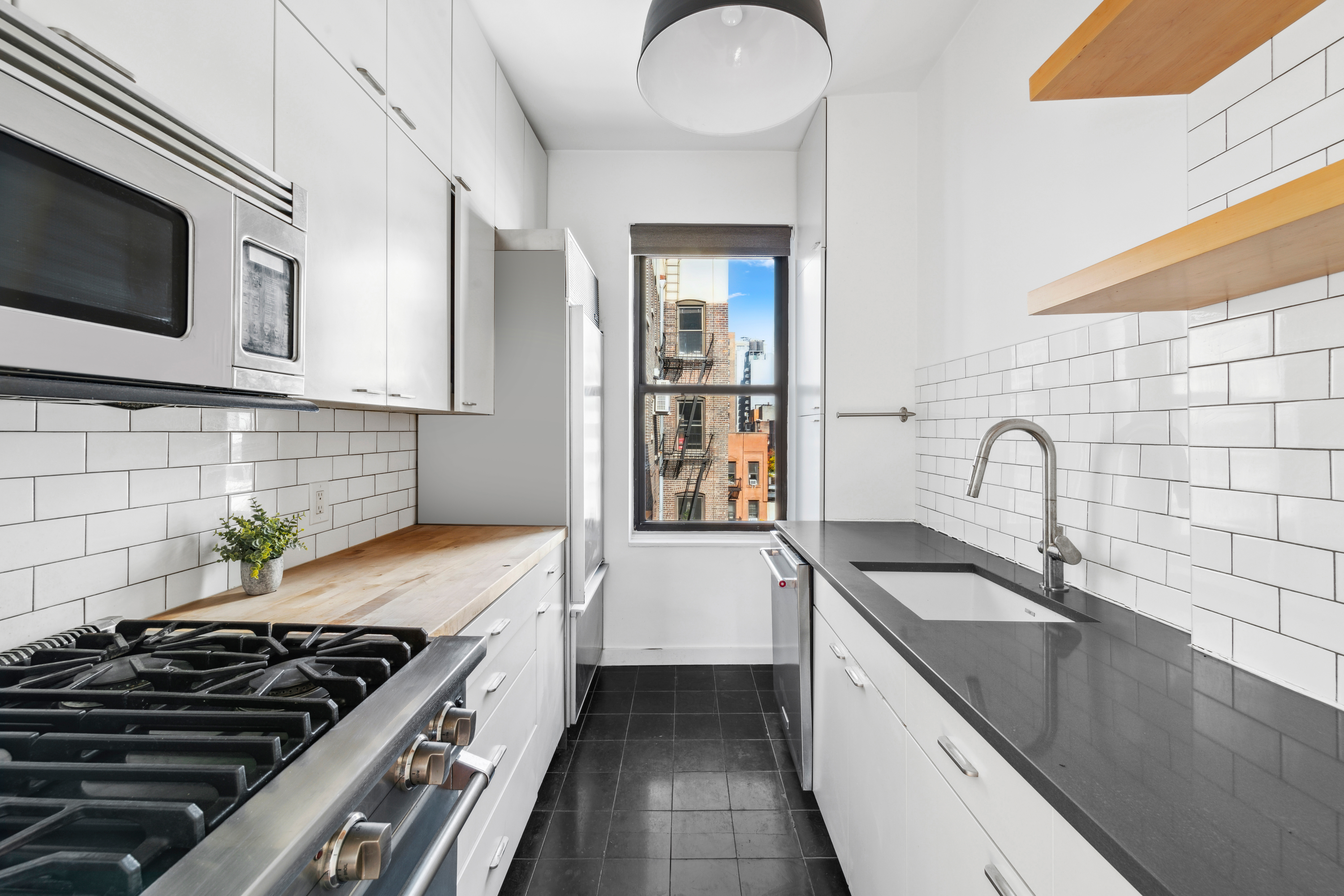210 West 21st Street, Unit 6RE Manhattan, NY 10011 - Photo 5 of 13 a kitchen with a sink and a stove top oven