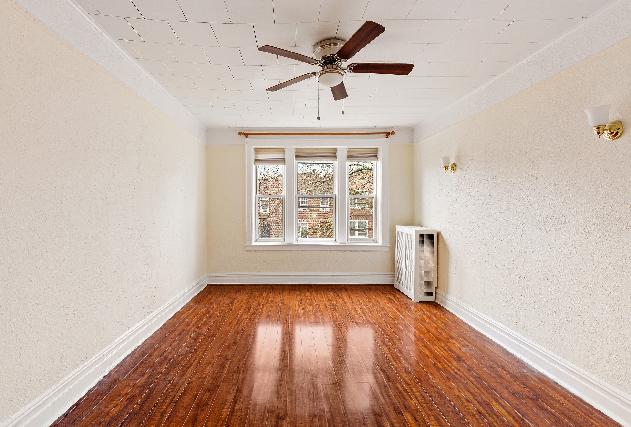 31-22 36th Street Queens, NY 11106 - Photo 2 of 10 an empty room with wooden floor and windows