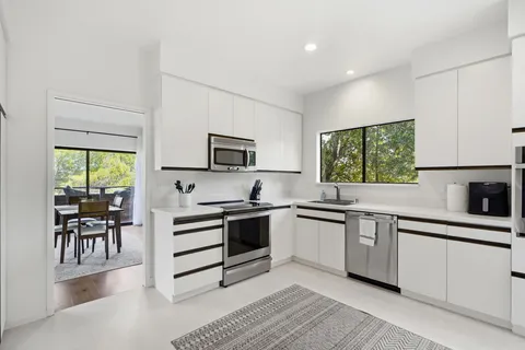a kitchen with granite countertop appliances cabinets and furniture