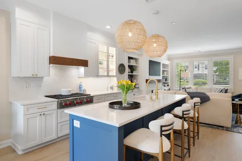 a kitchen with stainless steel appliances granite countertop a stove a kitchen island a dining table and chairs