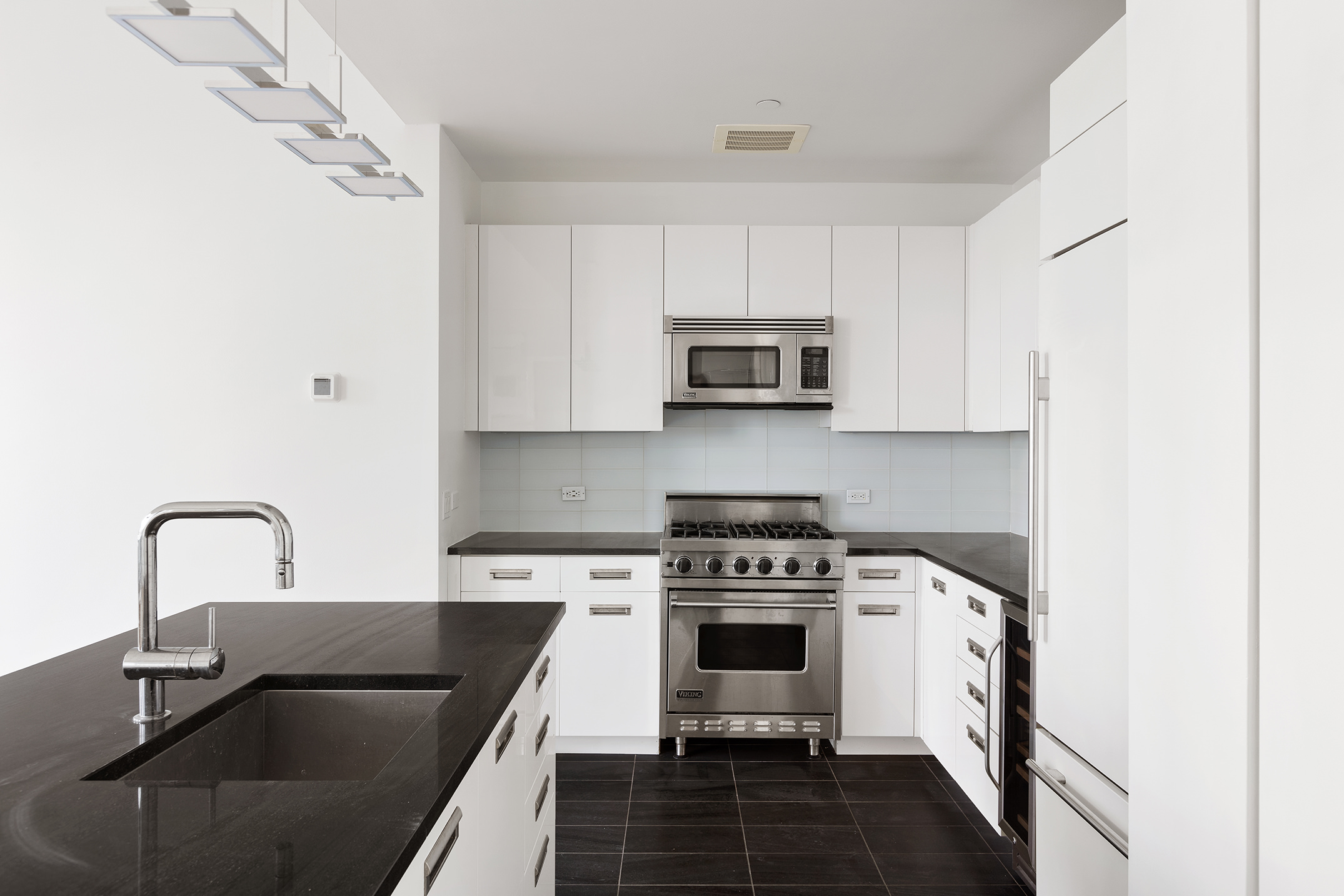 46-30 Center Boulevard, Unit PH8 Queens, NY 11109 - Photo 7 of 32 a kitchen with a stove a sink and a microwave