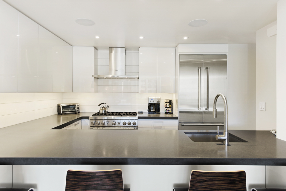 225 West 83rd Street, Unit 10K Manhattan, NY 10024 - Photo 4 of 21 a kitchen with stainless steel appliances granite countertop a sink and white cabinets