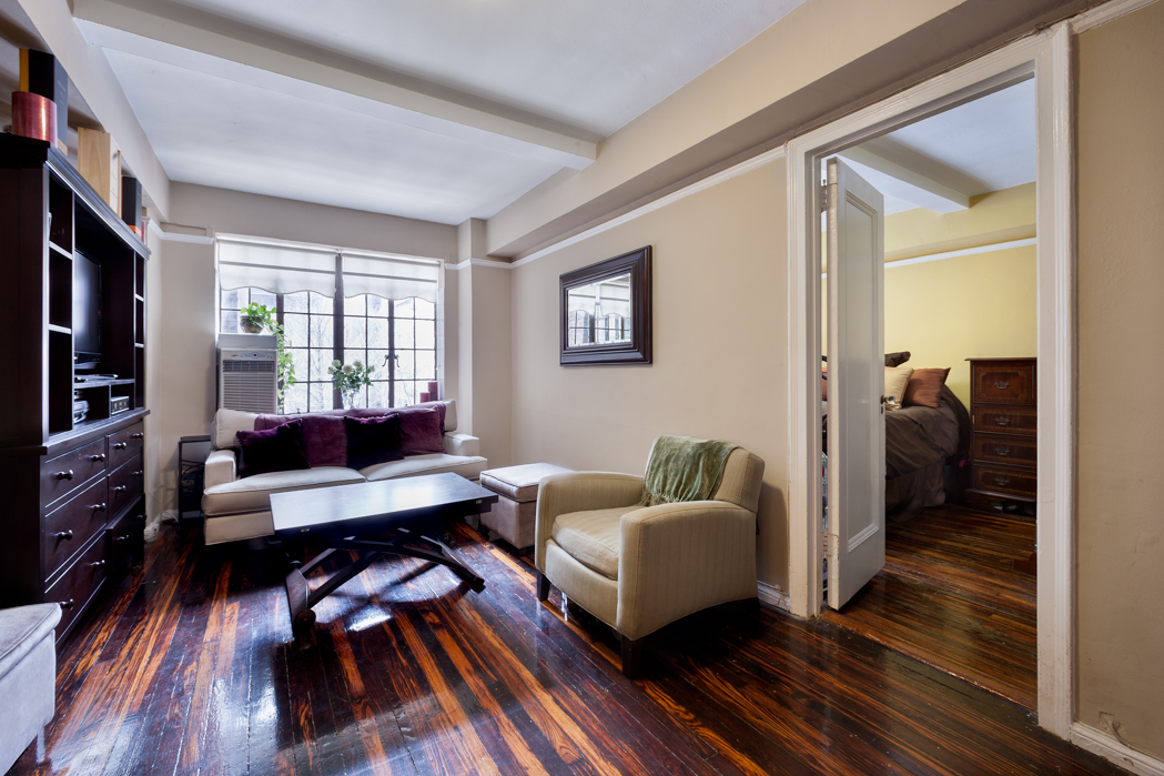 45 Tudor City Place, Unit 615 Manhattan, NY 10017 - Photo 1 of 5 a living room with furniture and a wooden floor