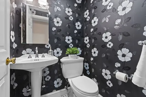 a white toilet sitting next to a bathroom sink
