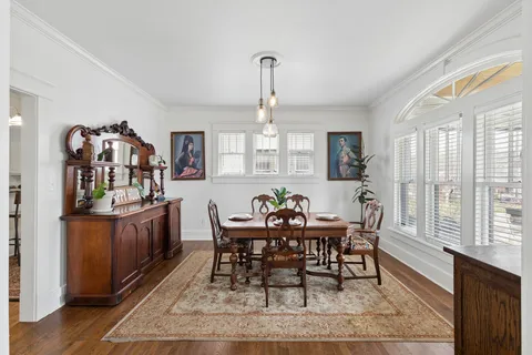 a kitchen with a table chairs a stove and a window