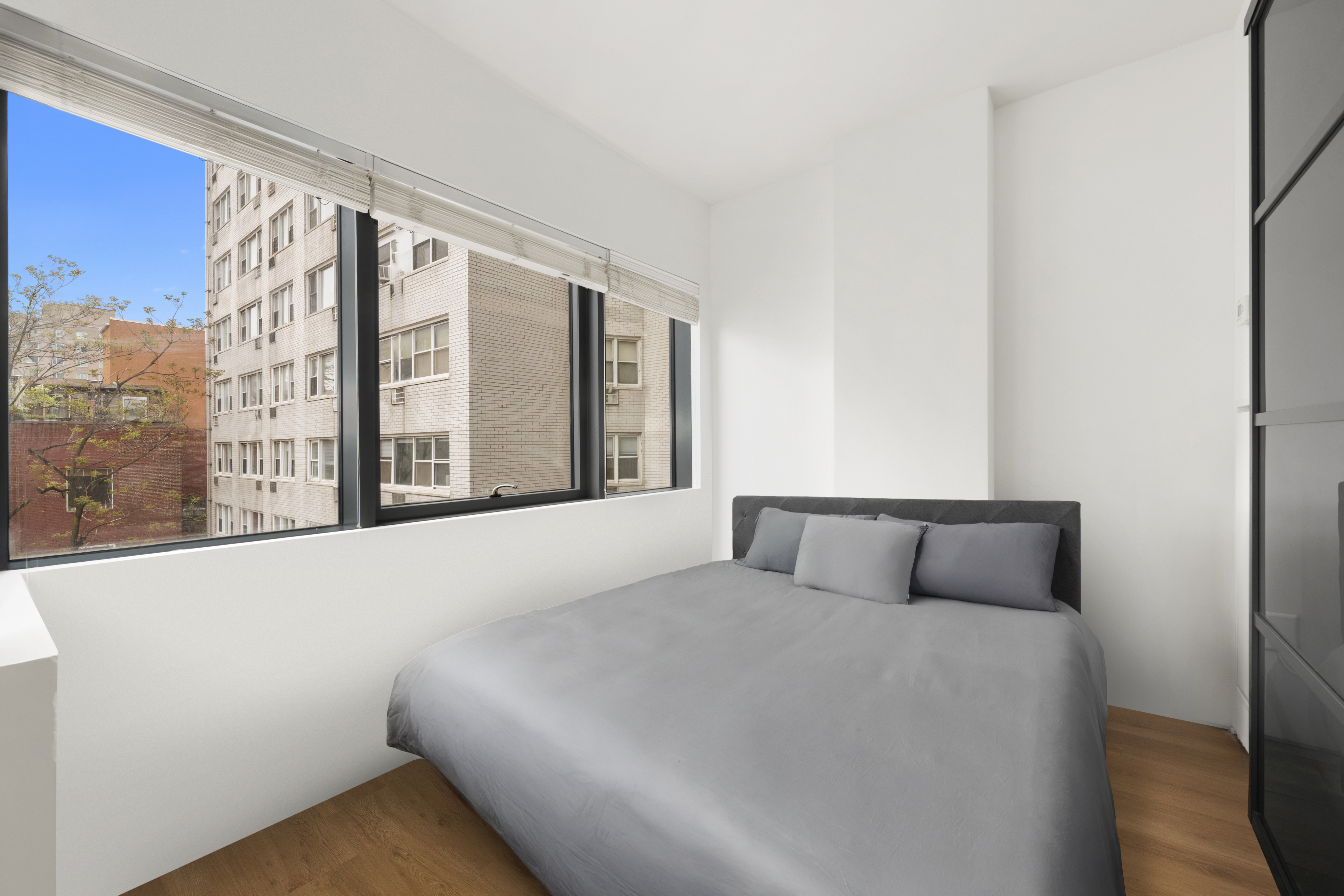 123 3rd Avenue, Unit 5D Manhattan, NY 10003 - Photo 5 of 12 a bedroom with a large bed and a large window