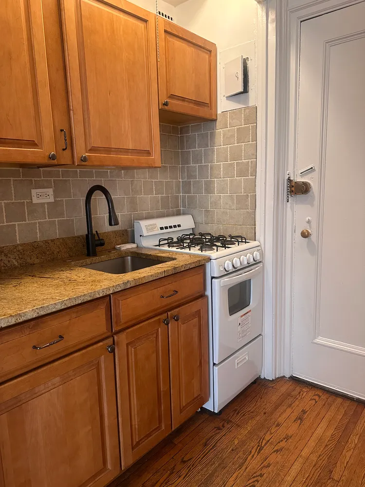 a kitchen with stainless steel appliances granite countertop a stove a sink and a microwave