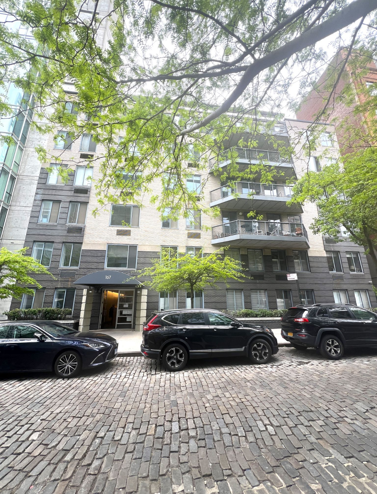 167 Perry Street, Unit 5K Manhattan, NY 10014 - Photo 9 of 10 a couple of cars parked in front of a building