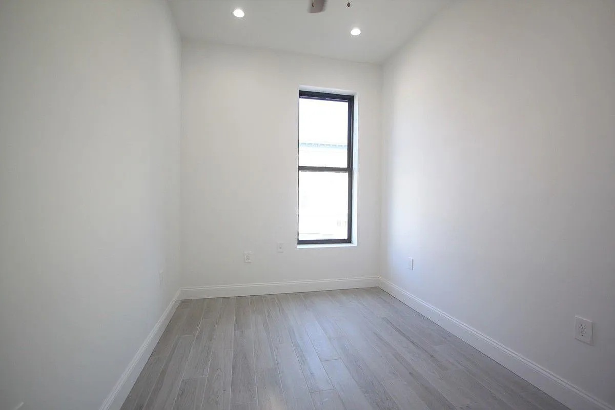186 Howard Avenue Brooklyn, NY 11233 - Photo 5 of 14 a view of a room with wooden floor and window