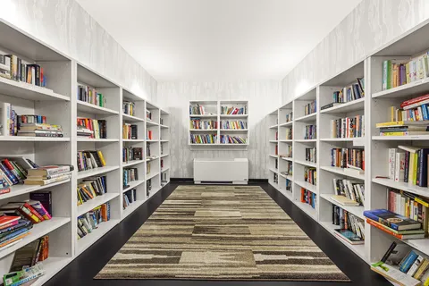 a view of room with windows book shelves
