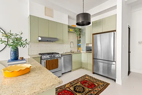 a kitchen with stainless steel appliances granite countertop a stove a refrigerator and a sink