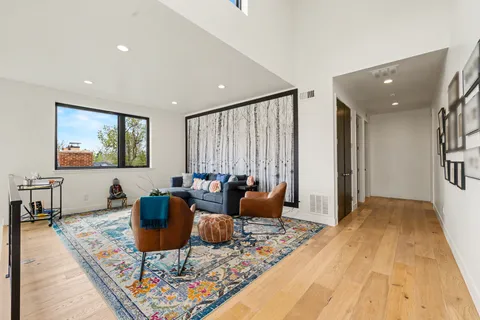 a living room with furniture a rug and a large window
