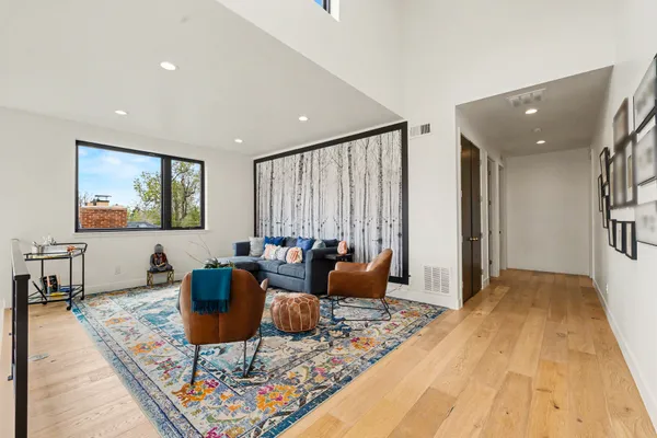 a living room with furniture a rug and a large window