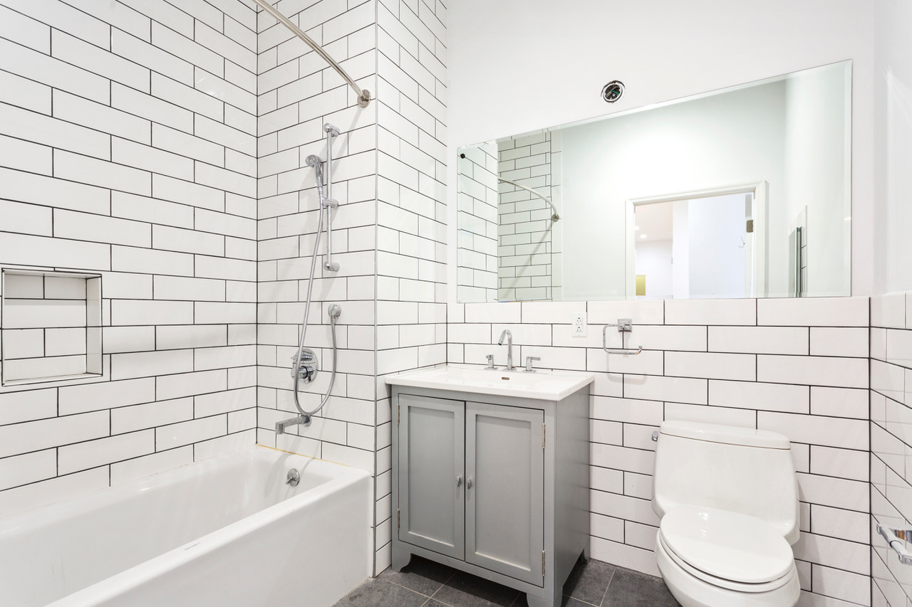 281 Grand Street, Unit 2R Manhattan, NY 10002 - Photo 11 of 11 a bathroom with a sink a toilet and mirror