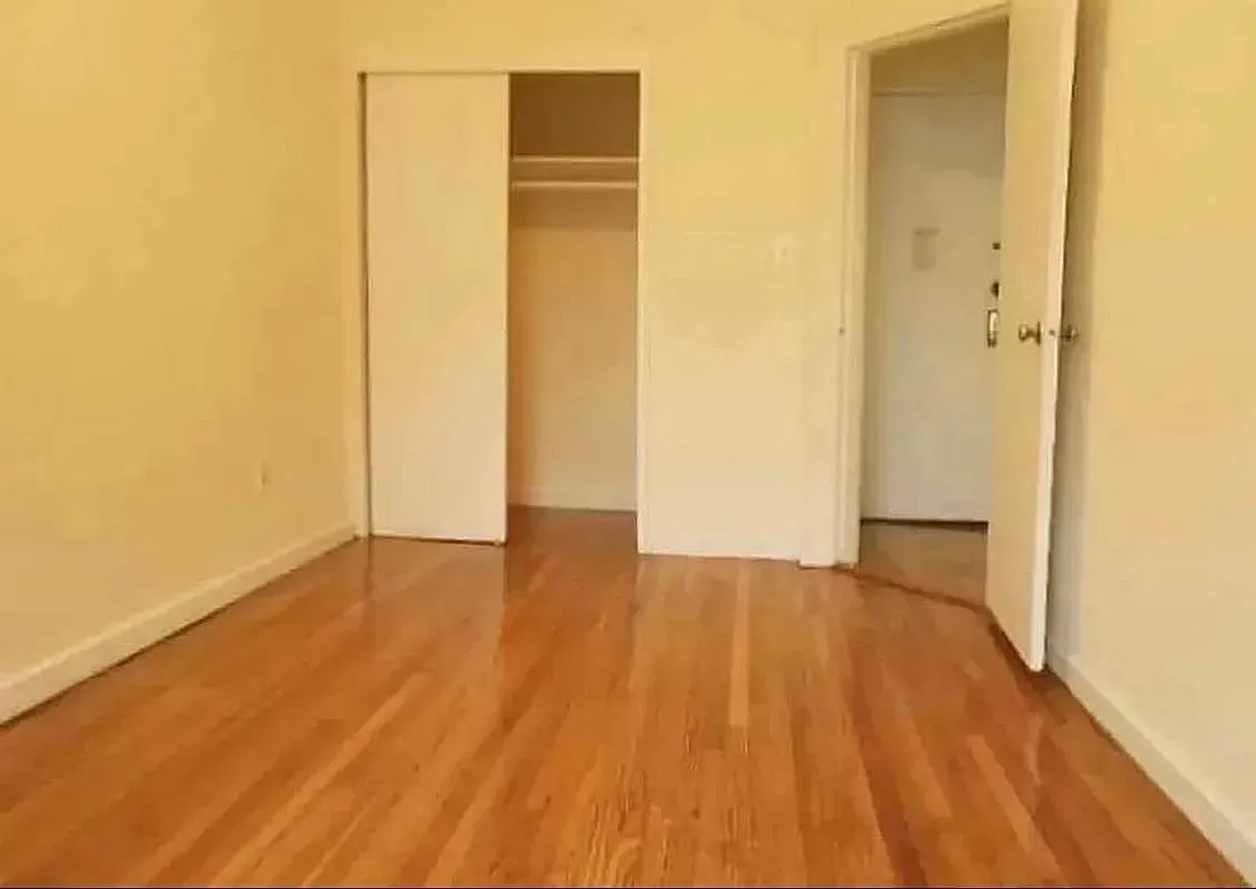 a view of empty room with wooden floor