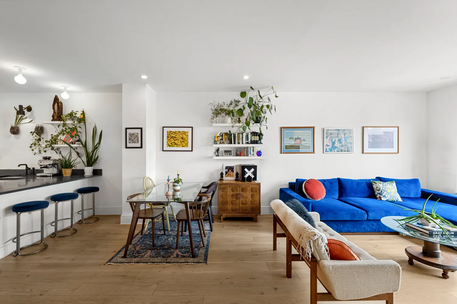 a living room with furniture and paintings on the wall
